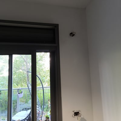 שקע חשמלי פתוח על קיר לבן ליד חלון זכוכית