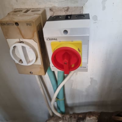 מתג חשמלי עם כפתור אדום וצהוב על קיר