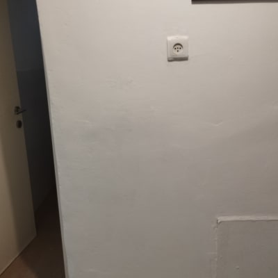 קיר עם שקע חשמל ותמונה תלויה
