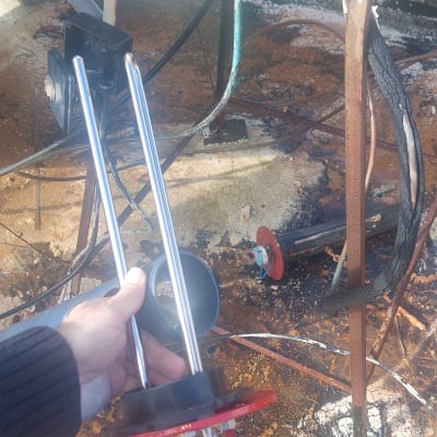 יד מחזיקה גוף חימום חשמלי ליד חוטים חשופים