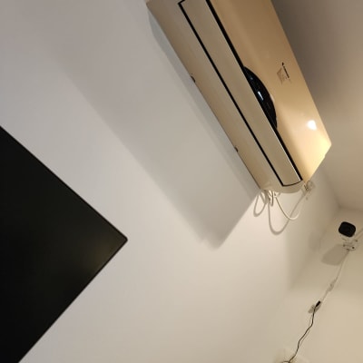 מזגן מותקן על קיר לבן עם חוטי חשמל