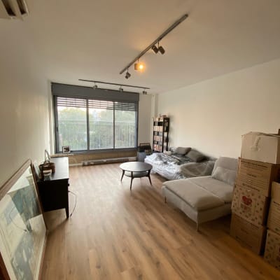 סלון עם ספה, שולחן, קופסאות אריזה ומדף ספרים