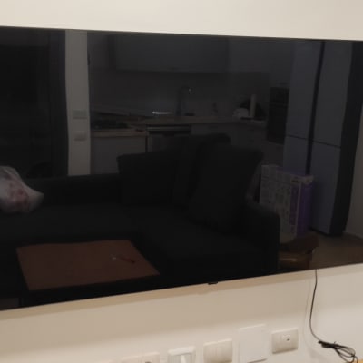 טלוויזיה תלויה על הקיר עם כבלים חשמליים