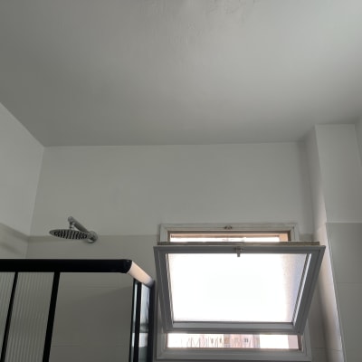 תקרה וקירות צבועים בחדר אמבטיה עם חלון פתוח