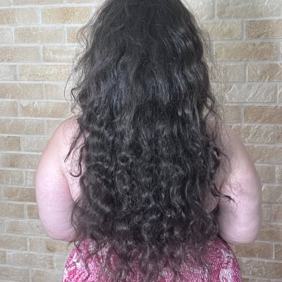 שיער ארוך ומתולתל על רקע קיר לבנים