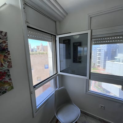 חלון עם תריסים פתוחים למחצה בחדר פנימי