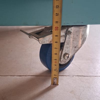מדידת גובה גלגל המורכב בתחתית רהיט באמצעות סרט מדידה