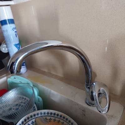 ברז מטבח כסוף מעל כיור עם כלים