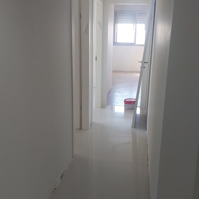 מסדרון עם דלתות ודלי צבע על הרצפה