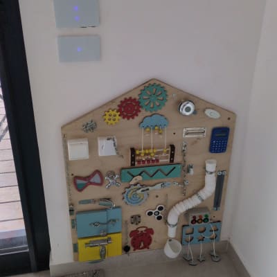 לוח פעילות עם כלים וצעצועים על קיר