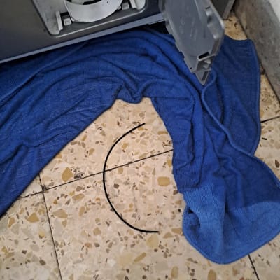 פתח מסנן מכונת כביסה עם מגבת כחולה