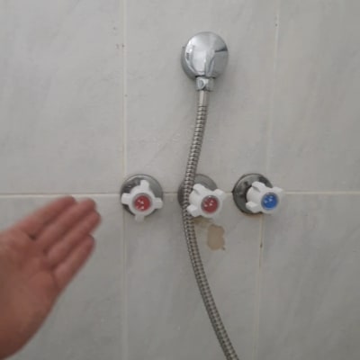 סוללת ברזים וידיות הפעלה למקלחון על קיר קרמיקה