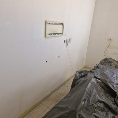 קיר צבוע עם מסגרת מסומנת, כיסוי פלסטיק על הרצפה