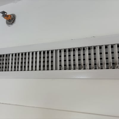 פתח אוורור מלוכלך על קיר לבן