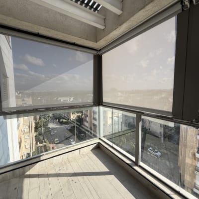 מרפסת עם סוככים שקופים לנוף עירוני