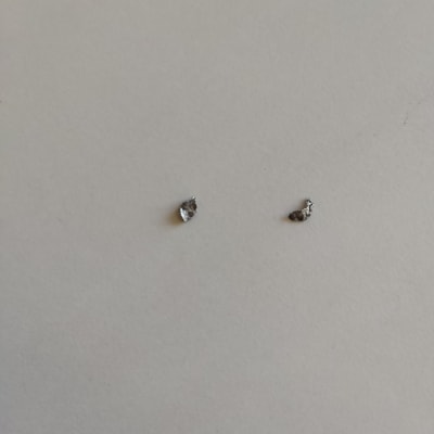 שני חלקי מתכת קטנים על רקע לבן