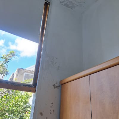 קיר עם קילופי צבע ליד חלון