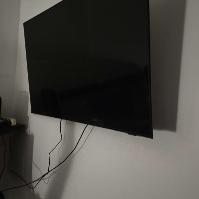 טלוויזיה תלויה על הקיר עם כבלים חשמליים