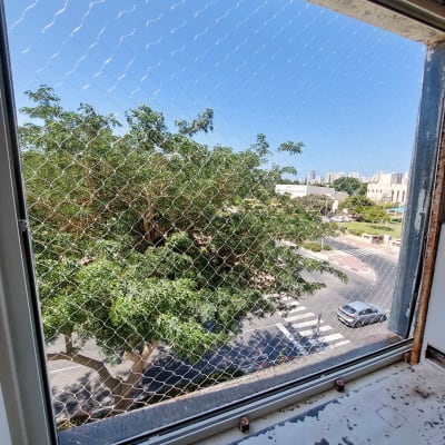 רשת יונים מותקנת על חלון למניעת כניסת יונים