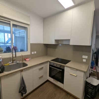 מטבח מודרני עם ארונות לבנים ותנור אפייה