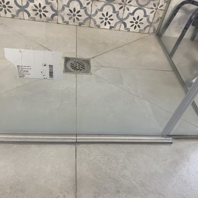 מקלחון עם רצפת קרמיקה ודלת זכוכית