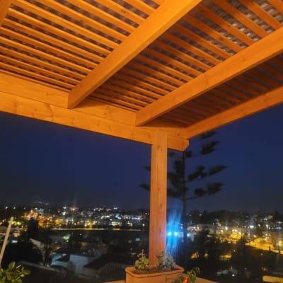 פרגולה מעץ עם צמחייה מסביב