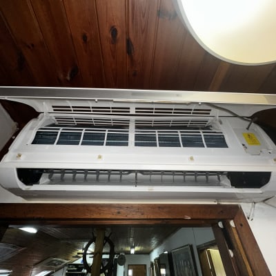 מזגן תלוי על קיר עץ עם תריסים פתוחים