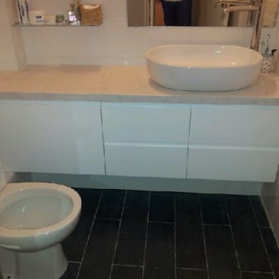 חדר אמבטיה עם ארון תלוי וכיור עגול