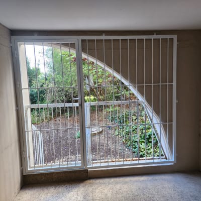 סורגי מתכת לבנים על חלון גדול עם קשת