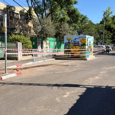 רחוב עם עצים ומבנה מגודר בסרט סימון