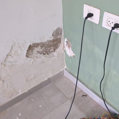 קיר עם קילופי צבע ושקעי חשמל