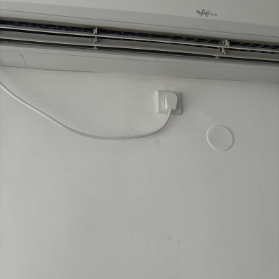 מזגן תלוי על קיר עם כבל חשמל מחובר