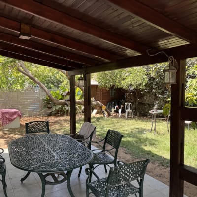 פינת ישיבה מעץ בגינה עם שולחן וכיסאות ברזל