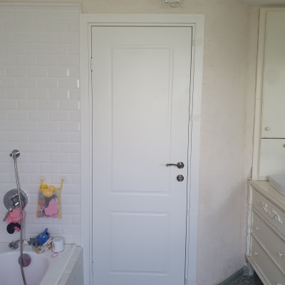 דלת לבנה עם ידית מתכת בחדר אמבטיה