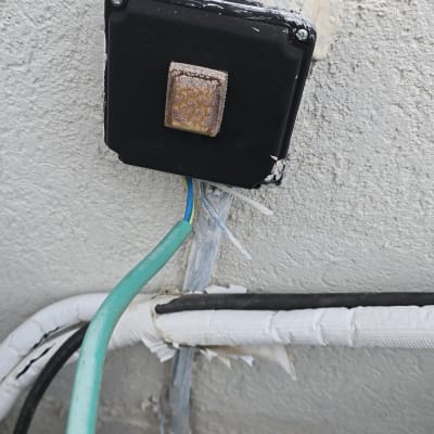 קופסת חשמל שחורה עם חוטים ירוקים ושחורים