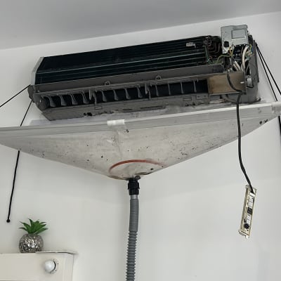 מזגן מפורק עם כיסוי ניקוז תלוי על הקיר