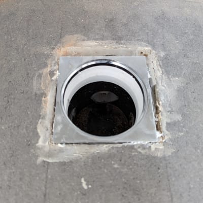 פתח ניקוז עגול ברצפה אפורה