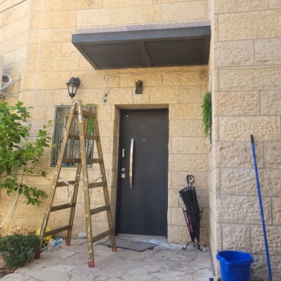 סולם עץ ליד דלת כניסה עם גגון