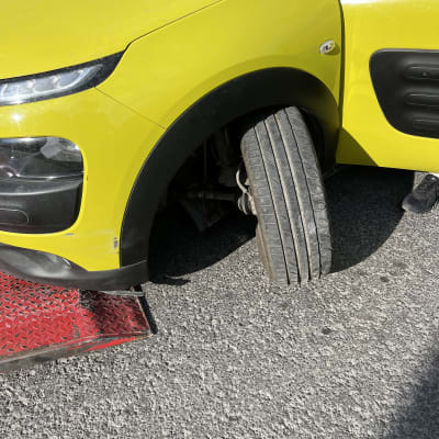 רכב צהוב על גרר עם גלגל פגום