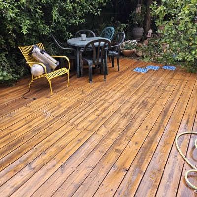 צינור מים על דק עץ רטוב בגינה