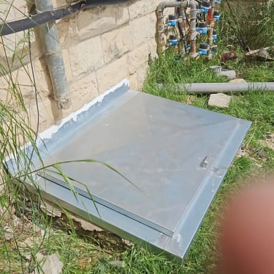 מסגרת מתכת על הקרקע ליד קיר אבן