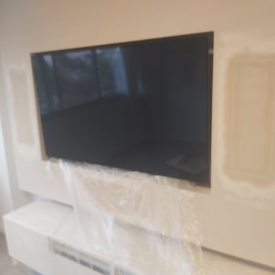 קיר גבס עם תיקוני שפכטל סביב טלוויזיה