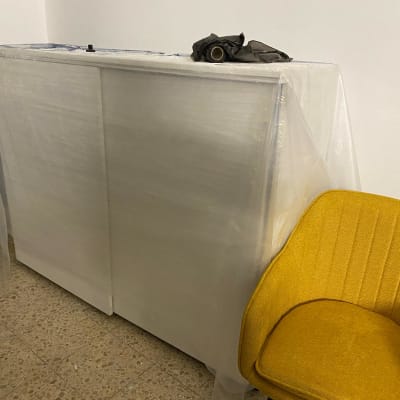 ארון מכוסה בניילון ליד כיסא צהוב