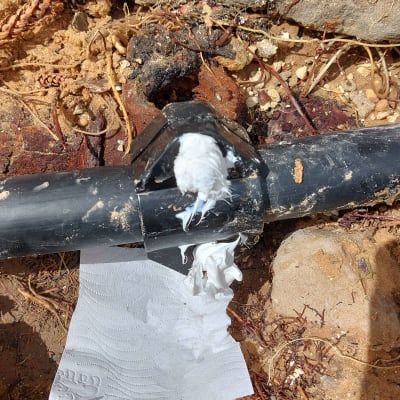 צינור שחור עם חומר איטום לבן על חיבור