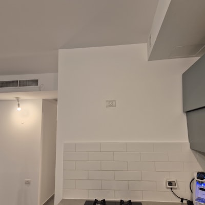 קיר צבוע עם אריחים וכלי עבודה לצביעה