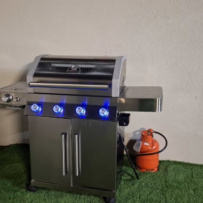 גריל גז עם כפתורים מוארים ומיכל גז כתום