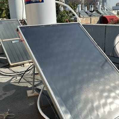 דוד שמש וקולטים על גג עם בניינים ברקע