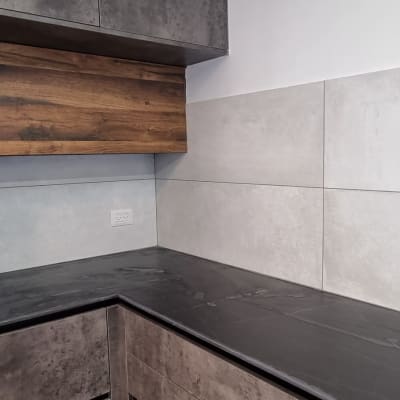 מטבח משופץ עם ארונות עץ ומשטח עבודה כהה