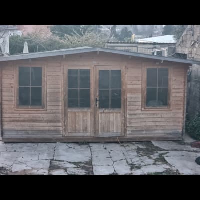 מחסן עץ עם דלתות זכוכית בגינה