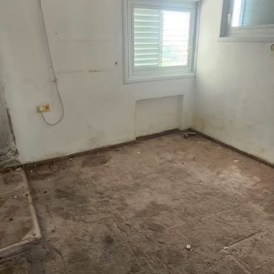 חדר ריק עם שטיח מלוכלך ומזגן על הקיר